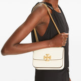 White bag carried by a person, showing the bag’s fit