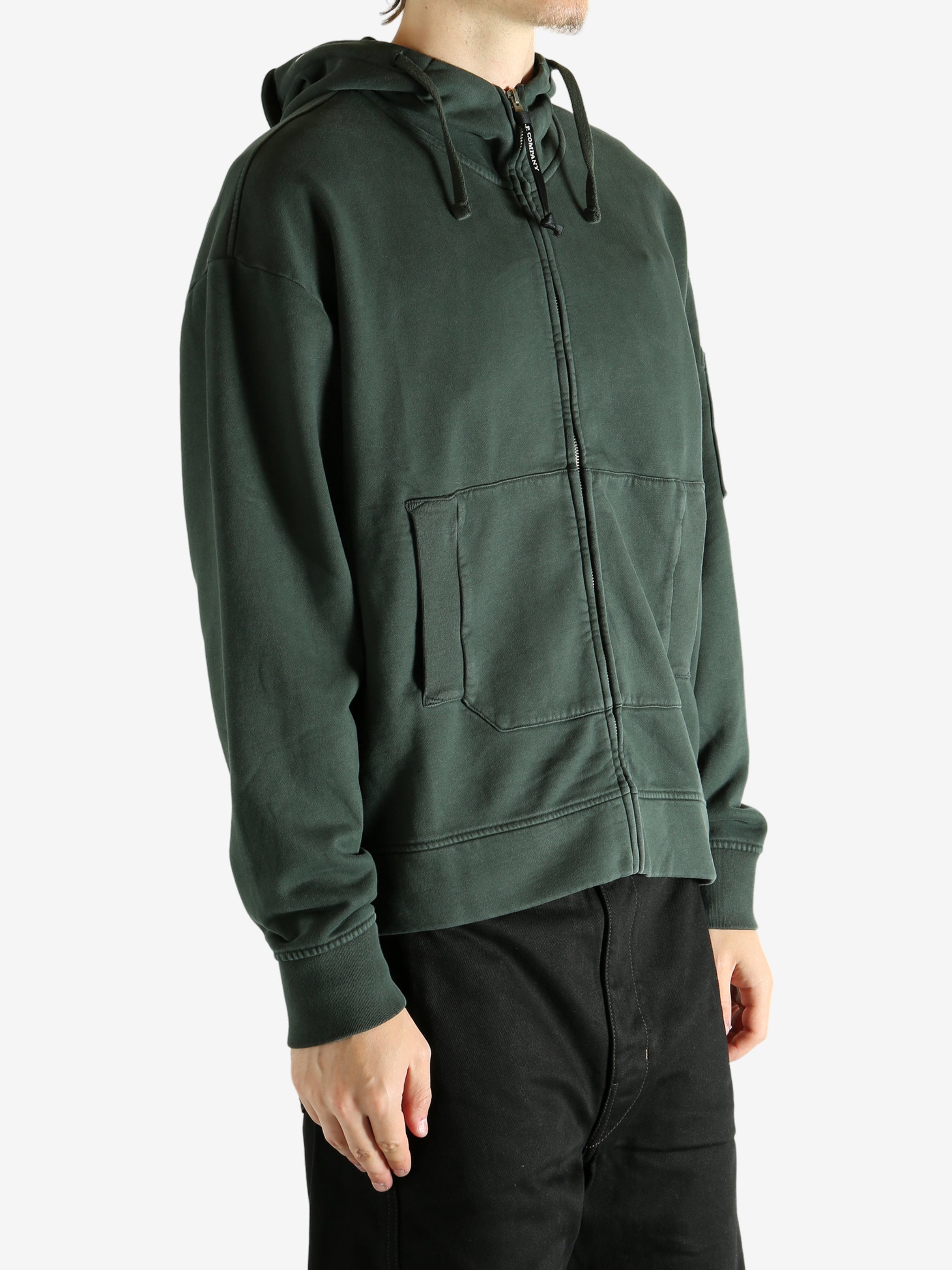 Green hoodie worn by a person, showing the hoodie's fit