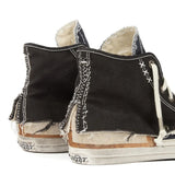 Close up of black sneakers, showing texture of the cotton and rubber and goat leather fabric