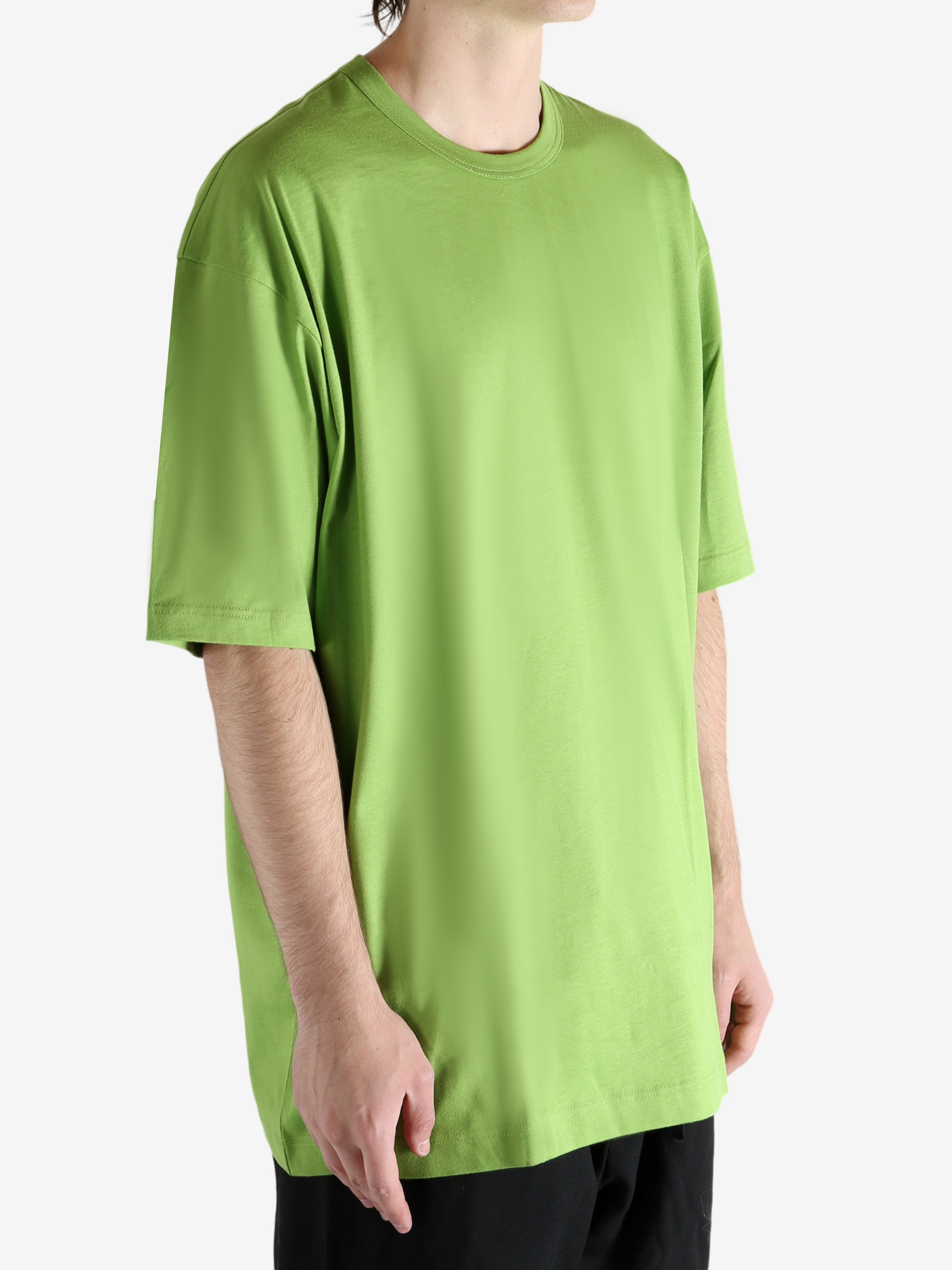 Green t-shirt worn by a person, showing the shirt's fit