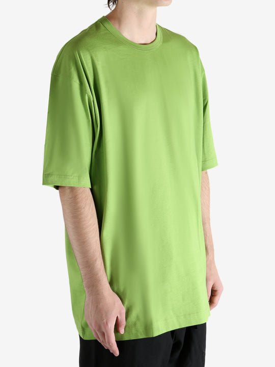 Green t-shirt worn by a person, showing the shirt's fit