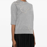 Grey sweater worn by a person, showing the sweater's fit