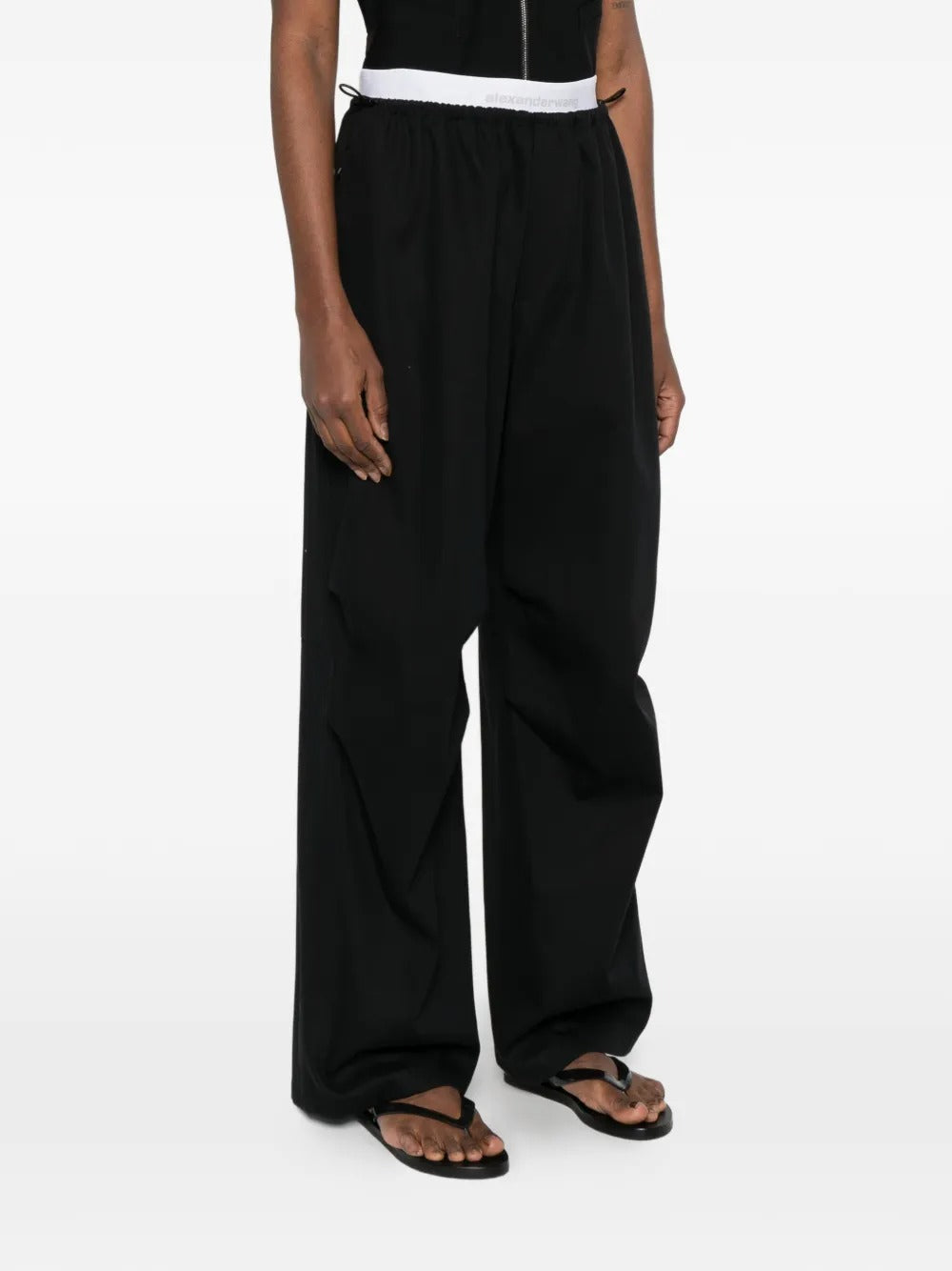Black pants worn by a person, showing the pants 's fit