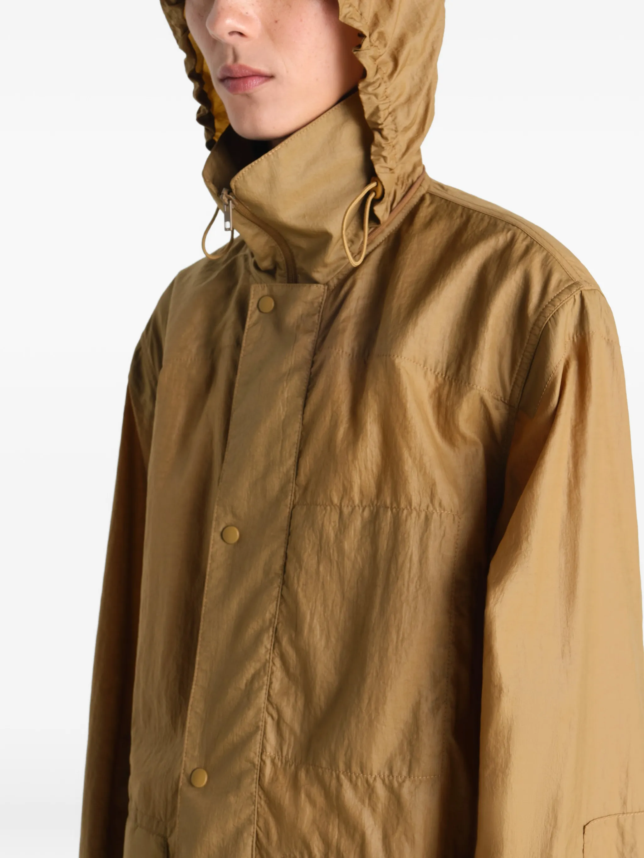 Close up of brown jacket, showing texture of the nylon fabric