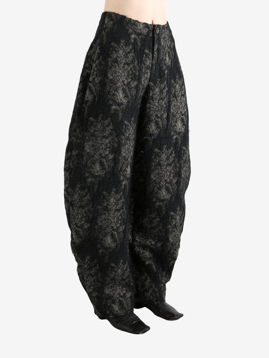 Black pants worn by a person, showing the pants's fit