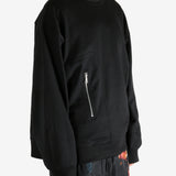 Black sweater worn by a person, showing the sweater's fit