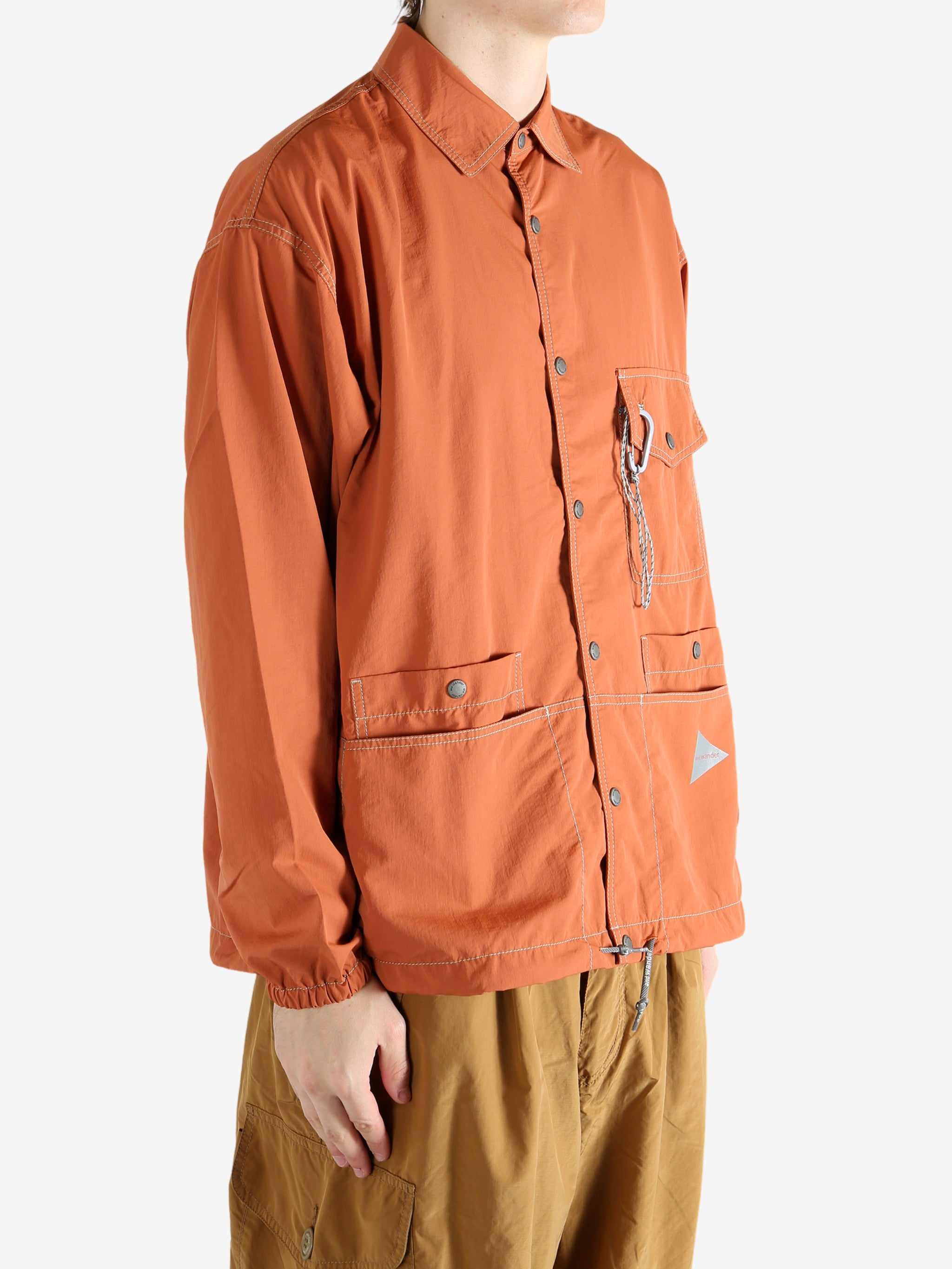 Orange jacket worn by a person, showing the jacket's fit