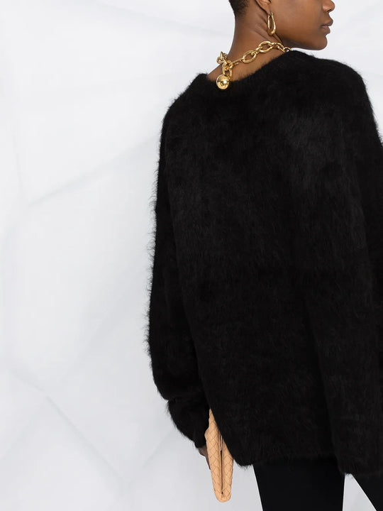 Black knitwear worn by a person, showing the knitwear fit