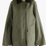 Green coat worn by a person, showing the loose fit.