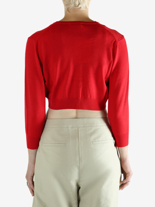Red cardigan worn by a person, showing the cardigan's fit