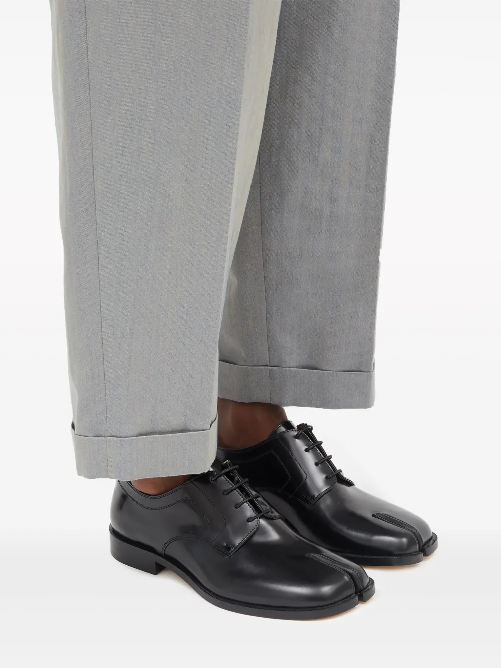 Black shoes worn by a person, showing the shoes's fit