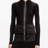 Black knitwear worn by a person, showing the knitwear's fit