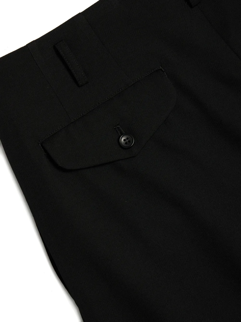 Close up of black pants, showing the detial of flap-pocket on the back 