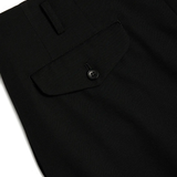 Close up of black pants, showing the detial of flap-pocket on the back 