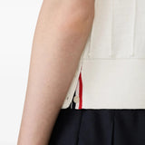 Close up of the white knitwear, showing texture of the wool fabric