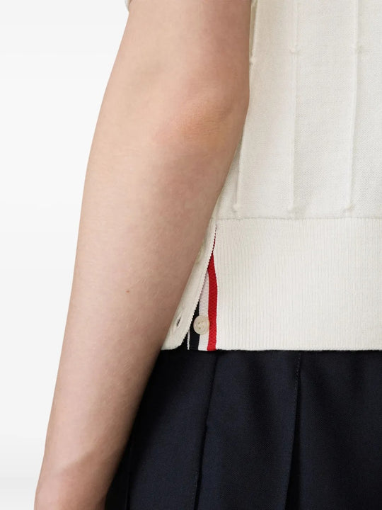 Close up of the white knitwear, showing texture of the wool fabric