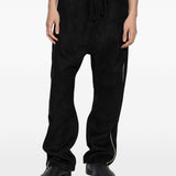 Black pants worn by a person, showing the pants' fit