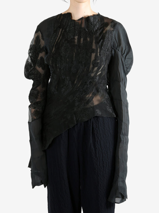 Black top worn by a person, showing the top's fit