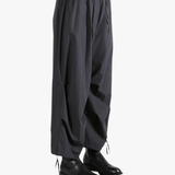 Black pants worn by a person, showing the pants' fit