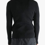 Black sweater worn by a person, showing the sweater fit