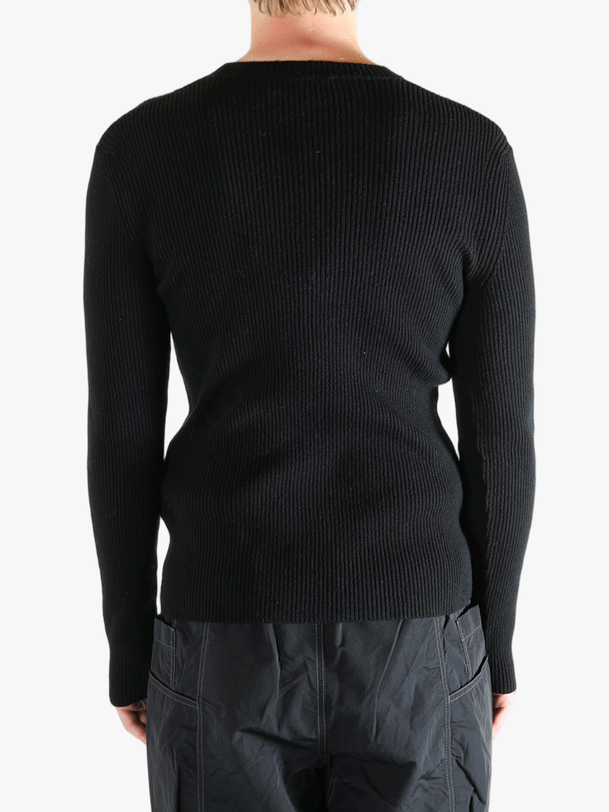 Black sweater worn by a person, showing the sweater fit