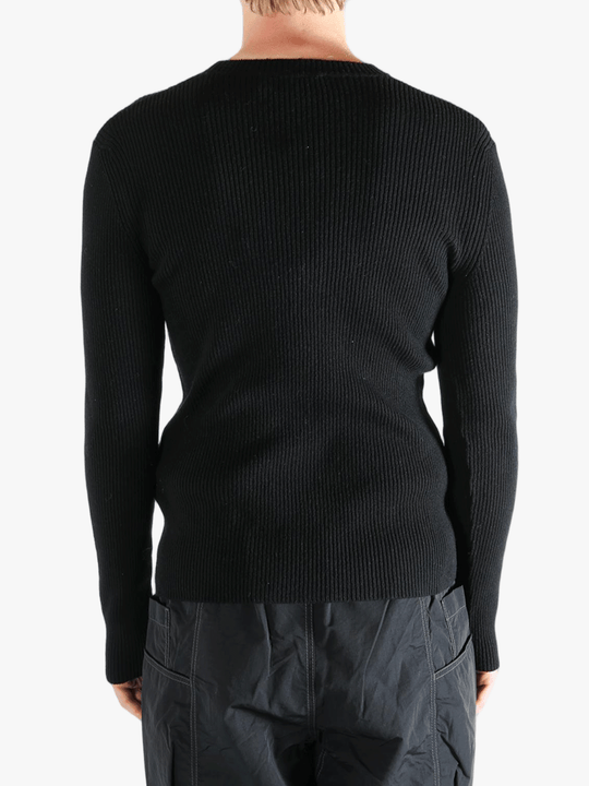 Black sweater worn by a person, showing the sweater fit