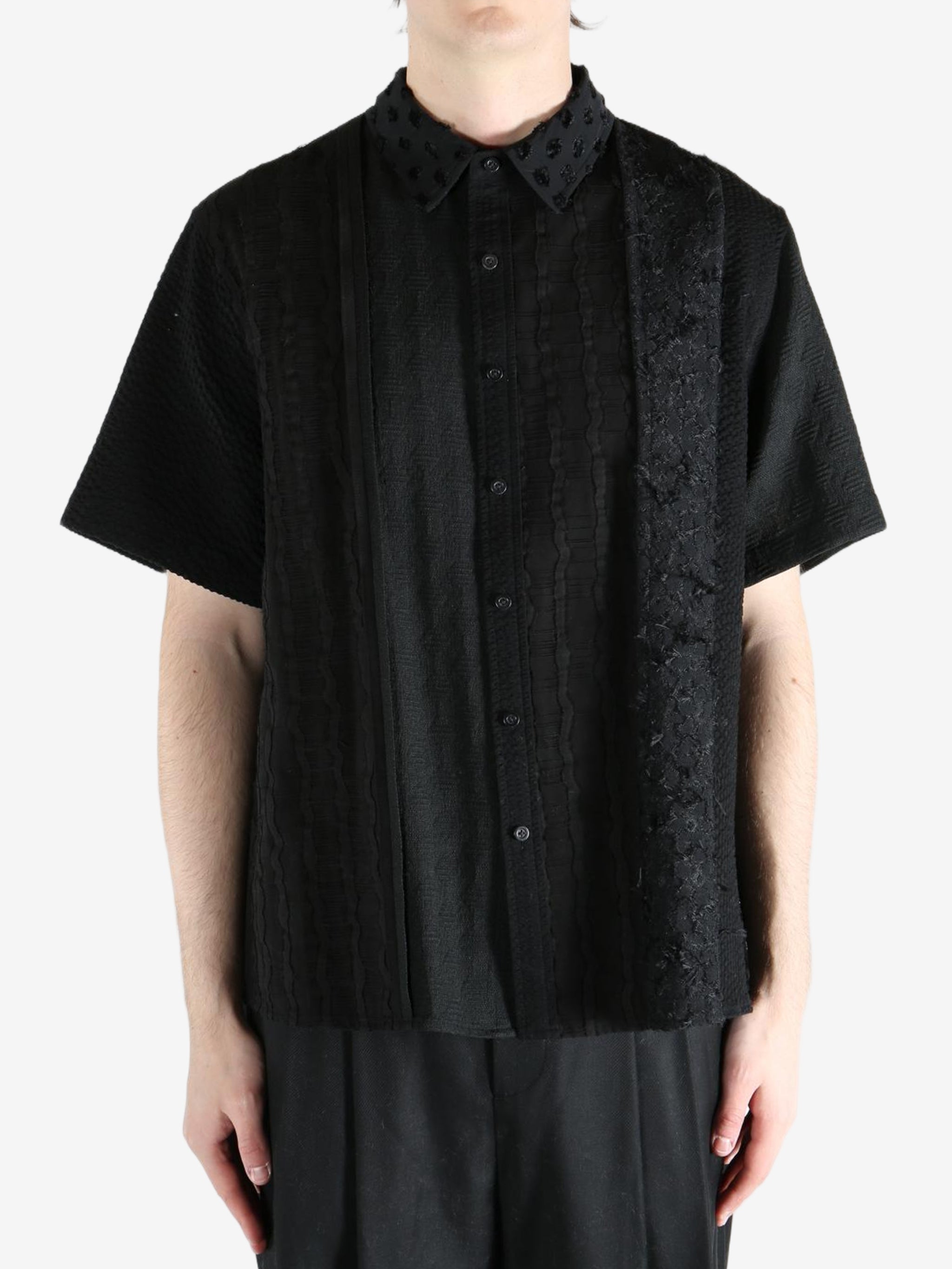 Black shirt worn by a person, showing the shirt's fit