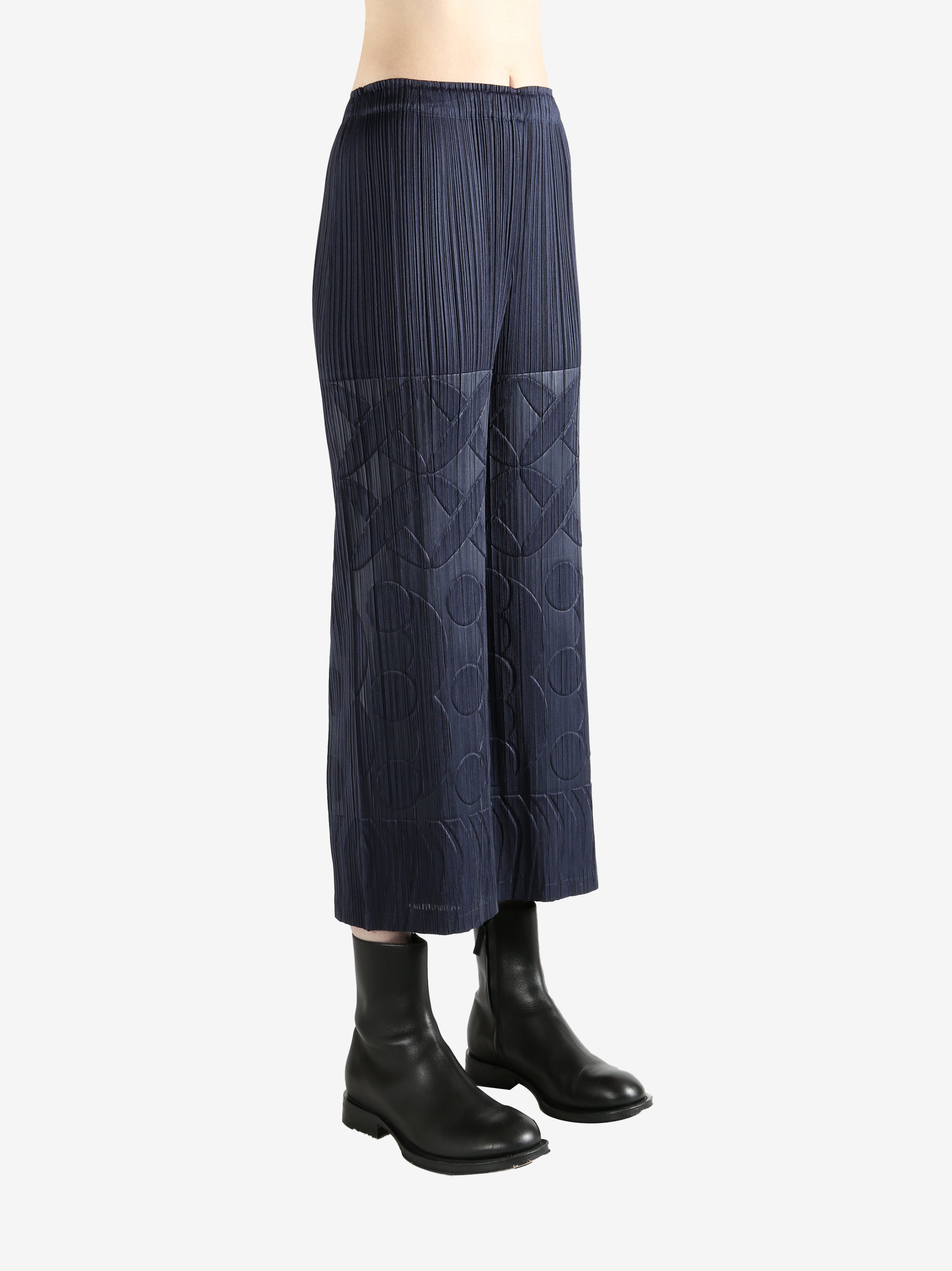 Navy pleated pants  worn by a person, showing the pants fit