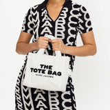 White bag carried by a person, showing the bag's fit