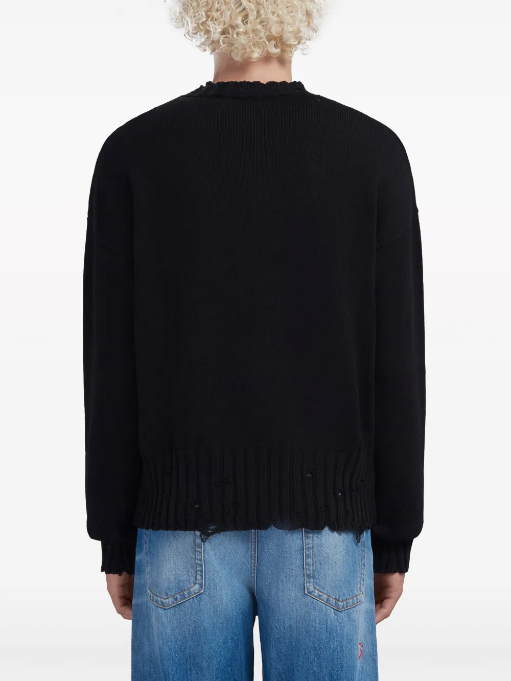 Black sweater worn by a person, showing the sweater's fit