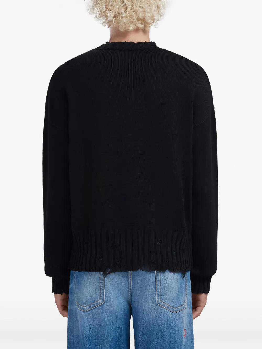 Black sweater worn by a person, showing the sweater's fit