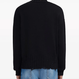 Black sweater worn by a person, showing the sweater's fit