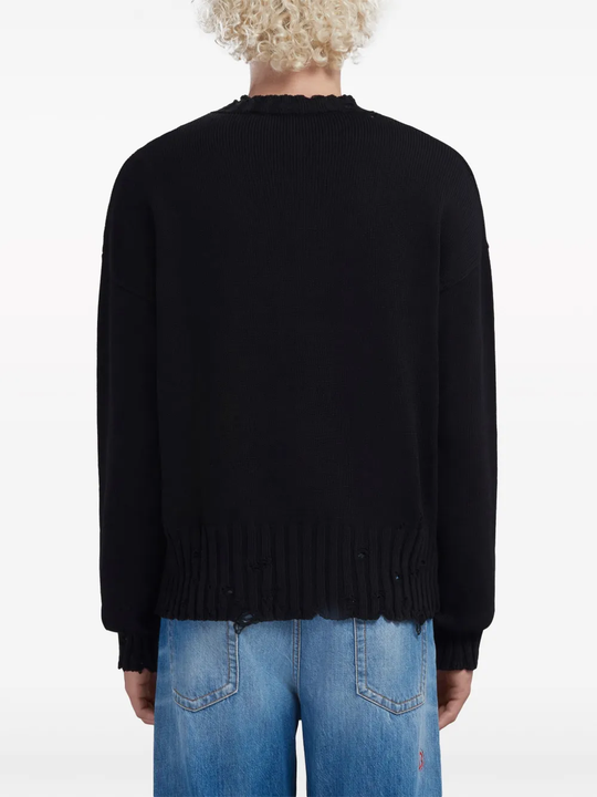 Black sweater worn by a person, showing the sweater's fit