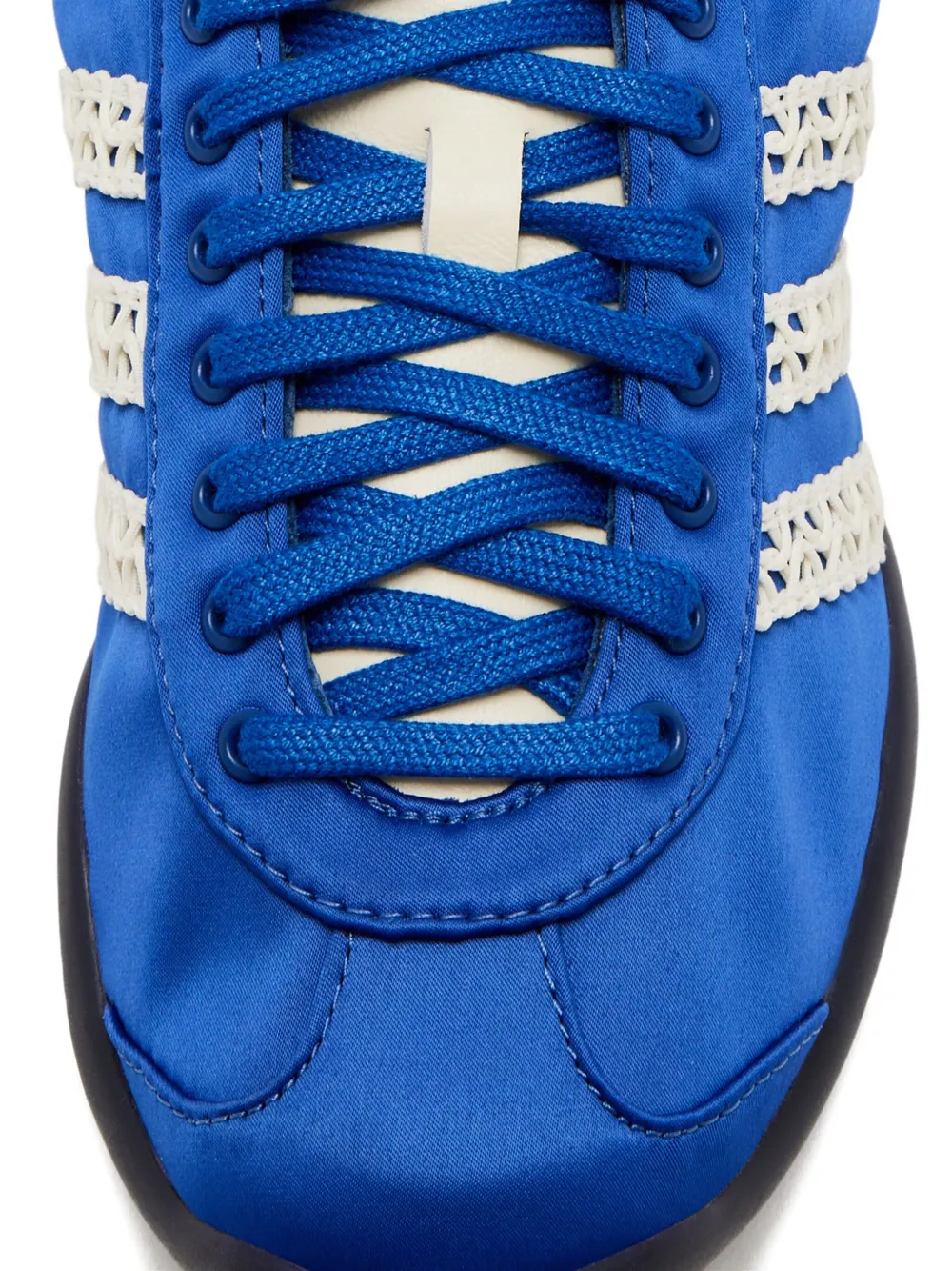 Close up of blue sneakers, showing texture of the textile and rubber fabric