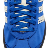 Close up of blue sneakers, showing texture of the textile and rubber fabric