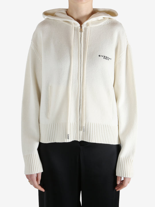 White knitwear worn by a person, showing the knitwear fit