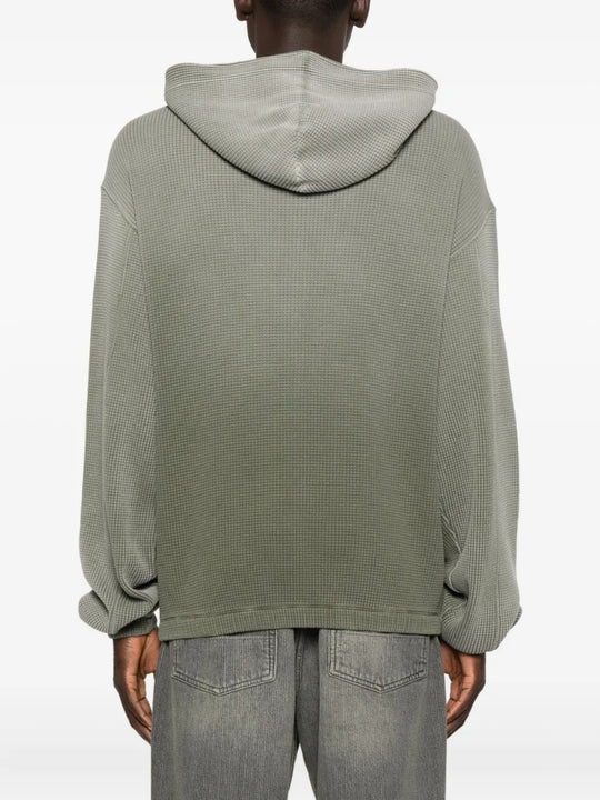 Green hoodie worn by a person, showing the hoodie's fit