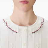 Close up of the white knitwear, showing texture of the wool fabric