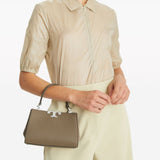 Brown bag carried by a person, showing the bag’s fit