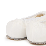 close up of white sneakers, showing texture of the cotton fabric