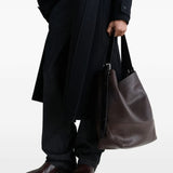 brown bag carried by a person, showing the size of the bag