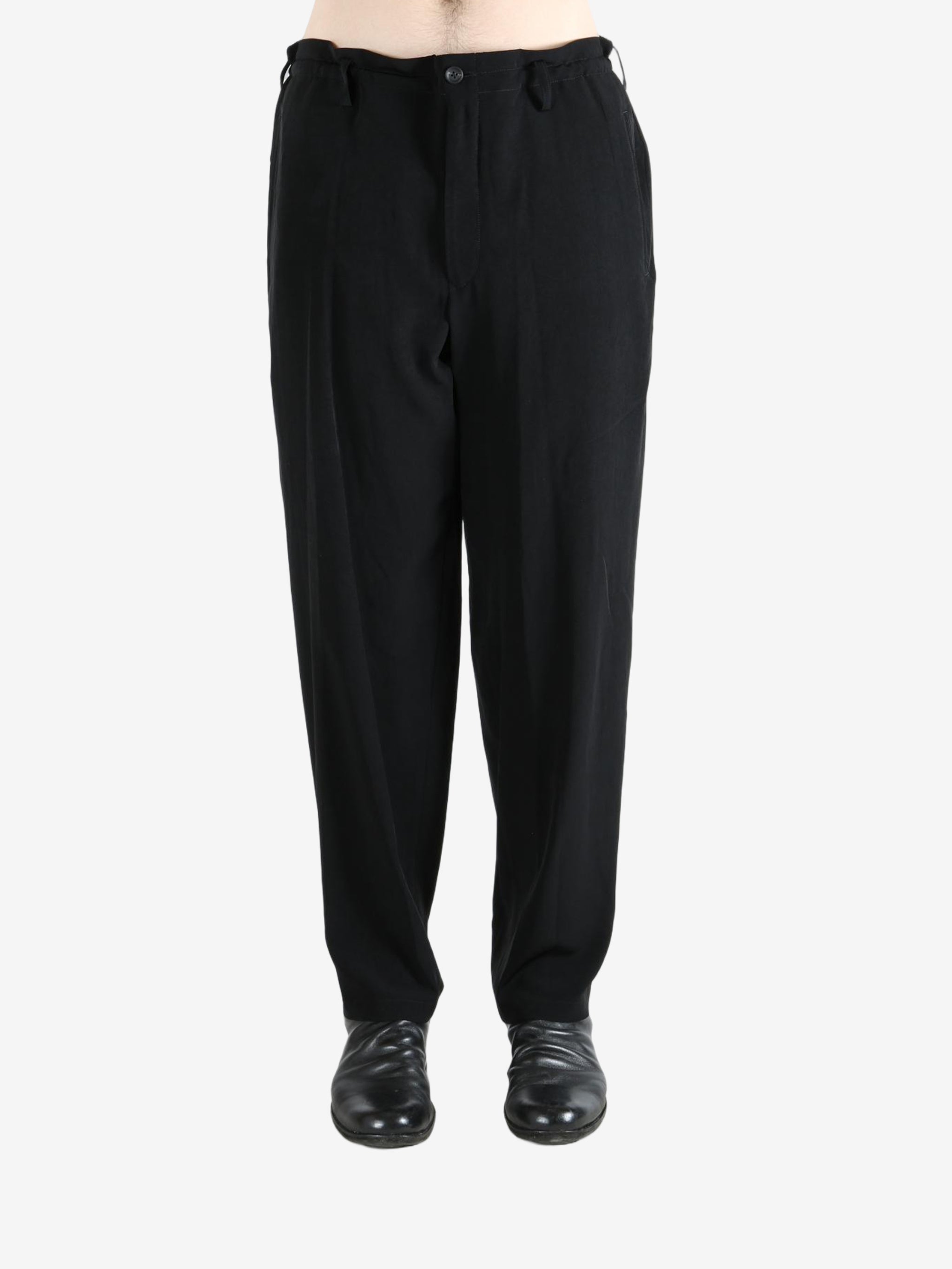 Black pants worn by a person, showing the pants's fit