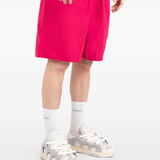Pink shorts worn by a person, showing the shorts fit