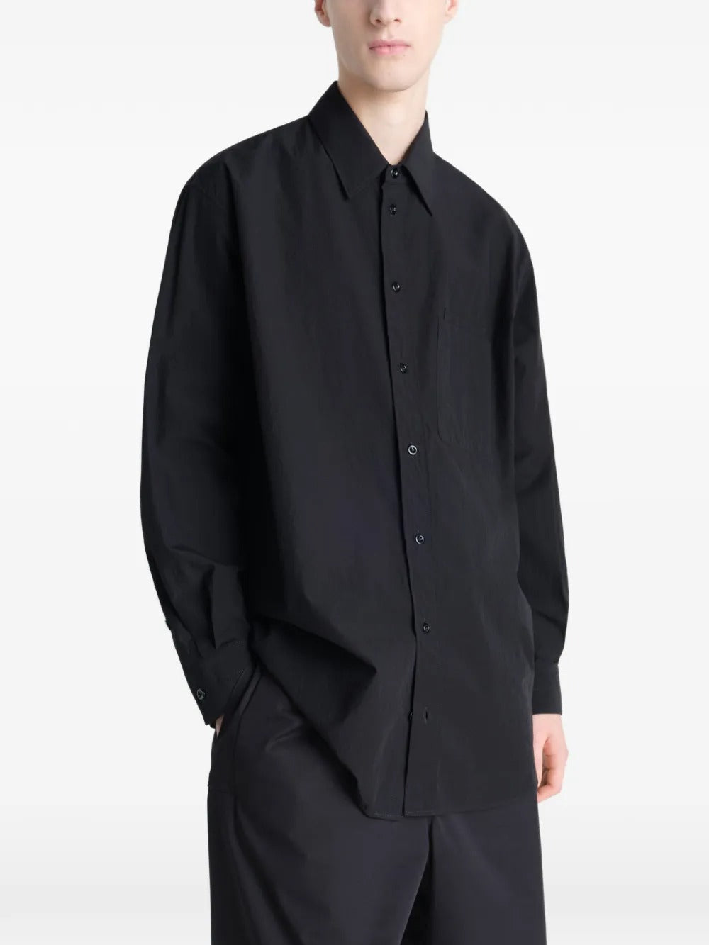 Black shirt worn by a person, showing the shirt's fit