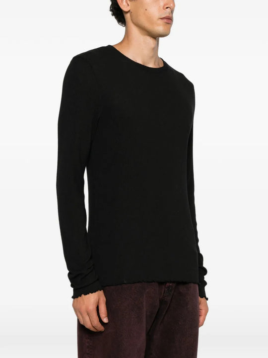 Black knitwear worn by a person, showing the knitwear fit