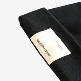 Close up of black hats, showing texture of the wool fabric