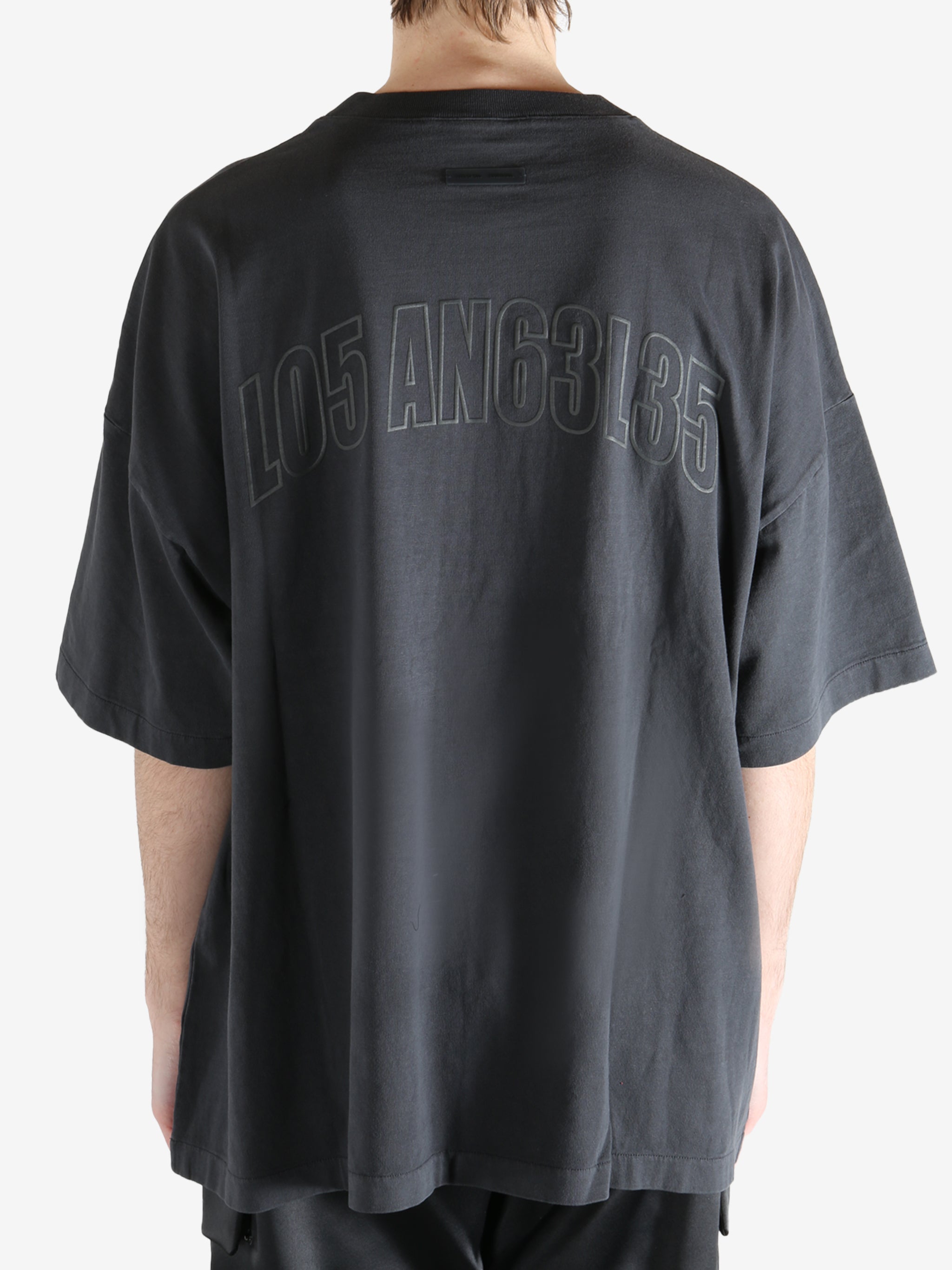 Black t-shirt worn by a person, showing the shirt's fit