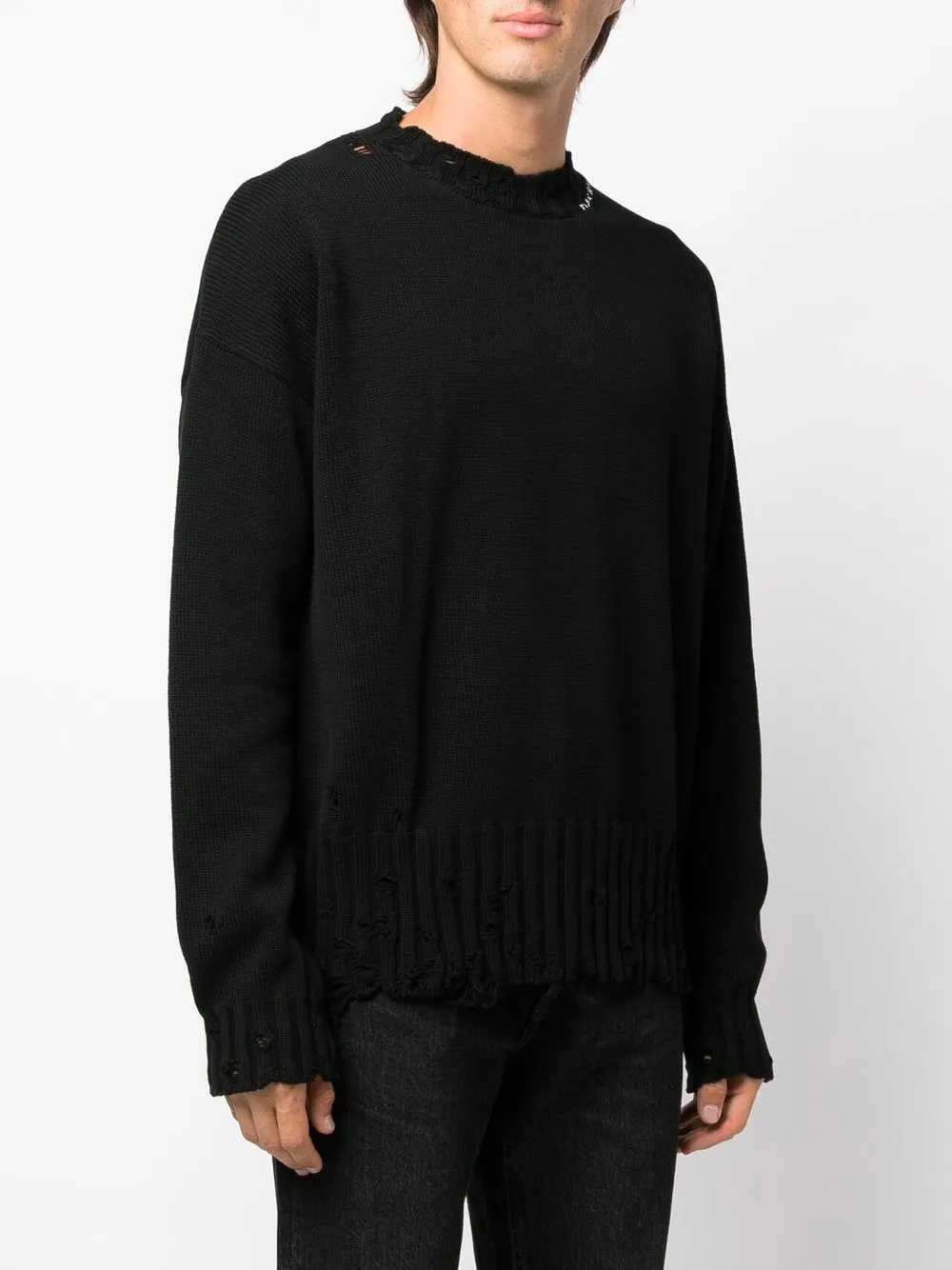 Black sweater worn by a person, showing the sweater's fit