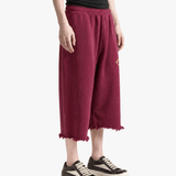 Burgundy pants worn by a person, showing the pants fit