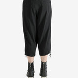 Black pants worn by a person, showing the pants's fit